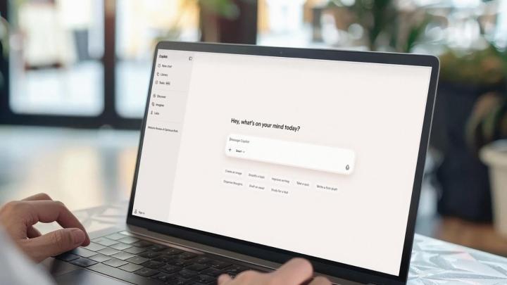 Person using a laptop displaying the Microsoft Copilot interface with a prompt field on the screen