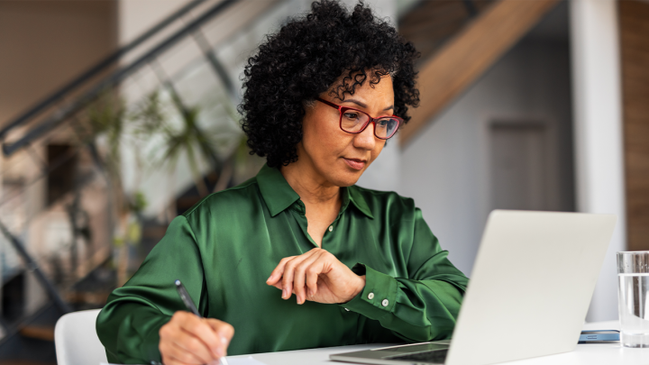 Lady in green shirt working on her laptop in the office