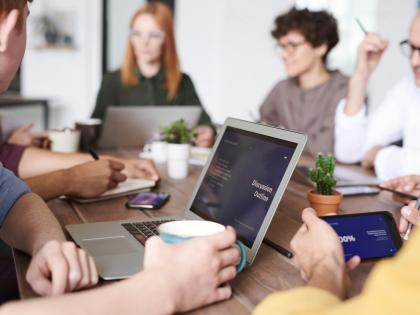 group of people meeitng at a table to discuss