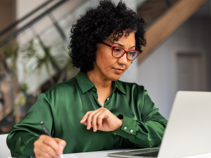 Lady in green shirt working on her laptop in the office