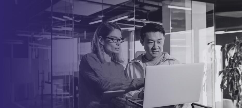 Two people reviewing work on a computer